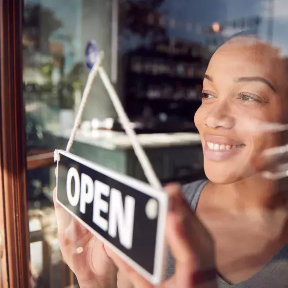 Black Female - Solo - in storefront setting - smiling