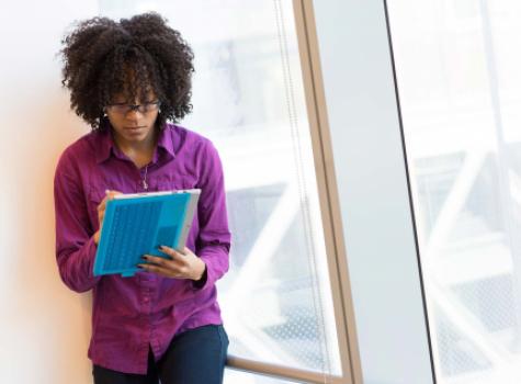 Black Female writing on Tablet - office setting