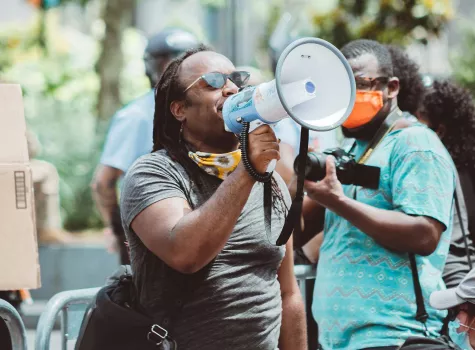 Black Male - Outdoors - Speaking to Group from Bullhorn