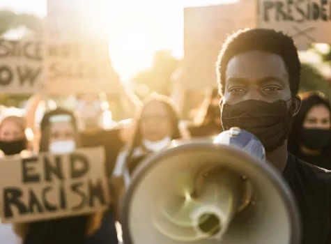 Black Male Standing with Protesters - Holding Megaphone