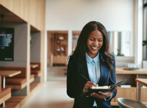 A Black woman in business attire smiles